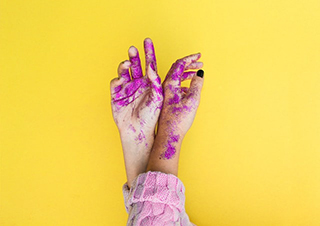 manos pintadas en purpura con fondo amarillo
