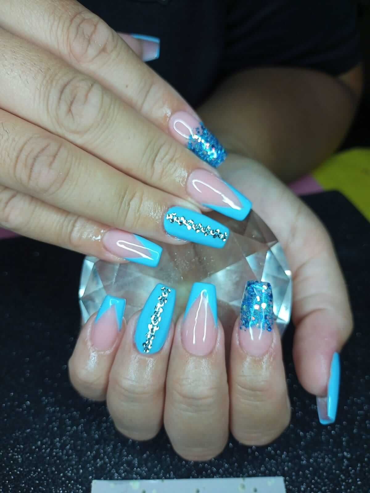 imagen de uñas pintadas en color celeste con brillo